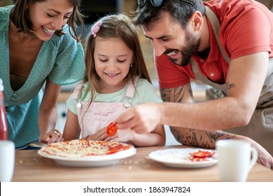 Little girl making pizza with her parents.Food,family and happiness concept. - Powered by Shutterstock