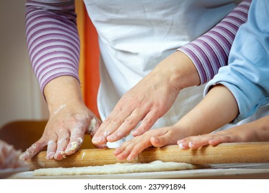 Little girl making pizza for lunch with her mother