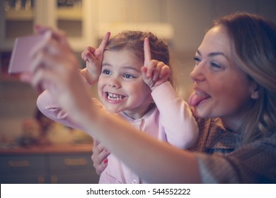 Little Girl Making Self Portrait With Her Mom. 