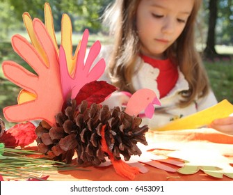 little girl making thanksgiving art project