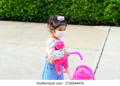 Little Girl with Mask and Baby Cart at The Garden Home
