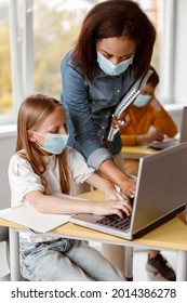 Little Girl In Mask Using Laptop During Lesson