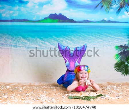 a little girl in a mermaid costume on the background of a Paradise island