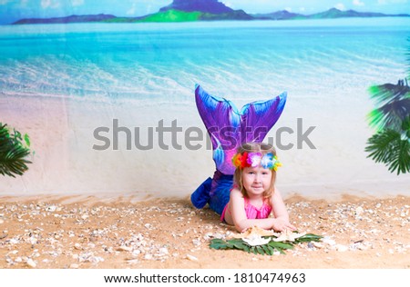 a little girl in a mermaid costume on the background of a Paradise island