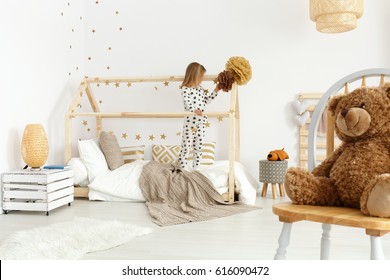 Little girl in modern brown and white scandi bedroom