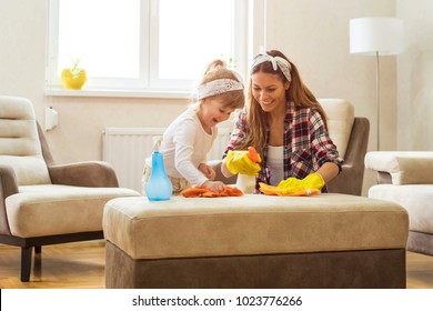 Little girl and  mother cleaning home together and having fun.