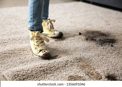 Little Girl In Muddy Shoes Messing Up Carpet At Home