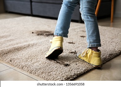 Little Girl In Muddy Shoes Messing Up Carpet At Home