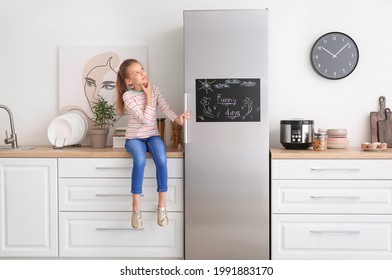 Little girl near chalkboard on refrigerator in kitchen - Powered by Shutterstock