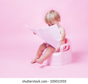Little girl with newspaper on the pot