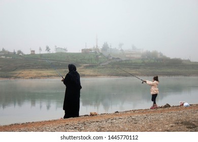 A Little Girl And Old Woman Fishing In The Foggy Weather  . 