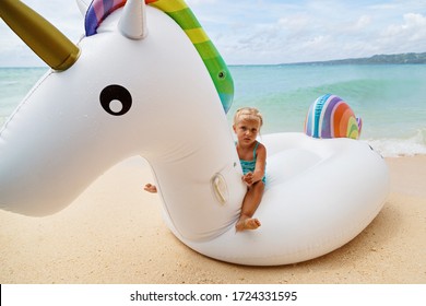 Little Girl On Inflatable Unicorn On The Sea. Travel Lifestyle, Swimming Activities In Family Summer Camp. Summer Vacations 2020 On Tropical Island After Coronavirus Covid-19 Lockdown Concept