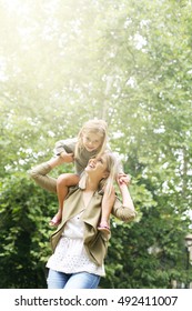 Little Girl On A Shoulder Ride With Her Mother.