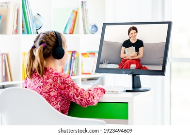 Little girl at online lesson with teacher via web cam on computer