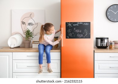 Little Girl Opening Big Refrigerator In Kitchen