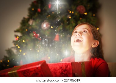 Little Girl Opening A Magical Christmas Gift Against Snow