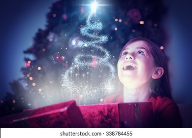 Little Girl Opening A Magical Christmas Gift Against Christmas Tree Design