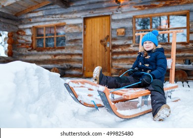 Little Girl Outdoors On Beautiful Winter Day In Front Of Log Cabin Vacation House