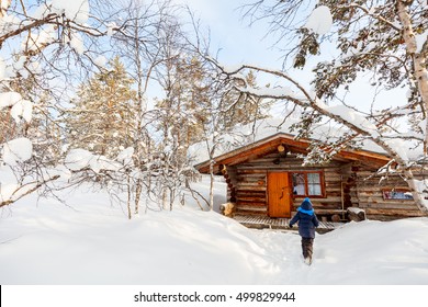 Little Girl Outdoors On Beautiful Winter Day In Front Of Log Cabin Vacation House