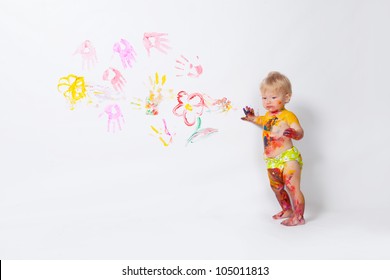 Little girl painting on the walls and floor in studio