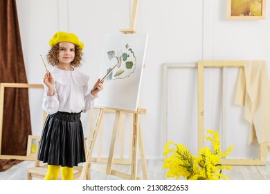 Little girl painting a picture in a studio or art school. Creative pensive painter child paints a colorful picture on canvas in workshop. Talented kids.  - Powered by Shutterstock