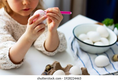 
Kleines Mädchen streicht Ostereier. Osterkonzept.	Vorbereitung auf Ostern. Frohe Ostern!