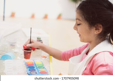 Little girl paints with tempera paints in her backyard, side view - Shutterstock ID 1707905098