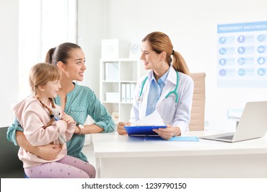 Little Girl With Parent Visiting Children's Doctor In Hospital