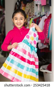 Little Girl Picking Out A Dress From The Closet