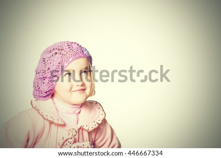 Little girl in a pink coat and beret isolated on white background.