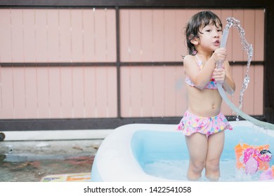 Little Girl Play In The Kiddie Pool.