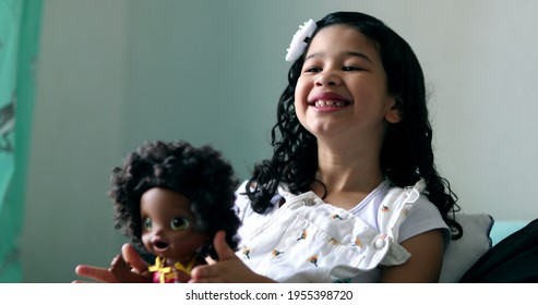 Little Girl Playing With Black Doll. Hispanic Child Plays With Doll