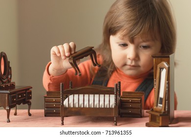 Little Girl Playing With Doll House Furniture