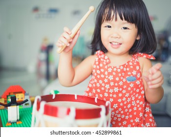 Little Girl Playing Drum At Home.Child Development.Art Music Online At Home.baby Child Toddler Girl Play Drum.Music Percussion Play With Red Shirt.Homeschool Kid.Pre Kindergarten Drummer.Talent Music.