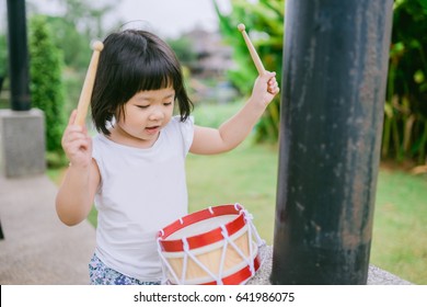 Little girl playing drum at home.Child development concept.