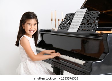 Little girl playing grand piano at home - Powered by Shutterstock