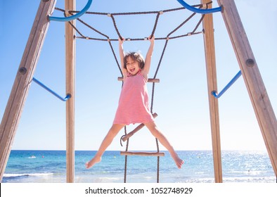 Little girl playing Monkey bars on the beach - Powered by Shutterstock