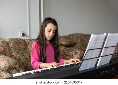 little girl playing on a new synthesizer in the old room
