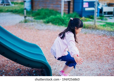 Little Girl Playing On The Slide