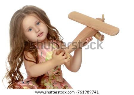Little girl is playing with a plane. Concept of happy childhood, playing in kindergarten, on the playground, at school.