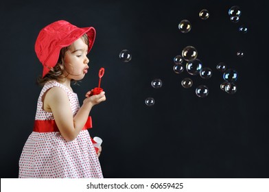 Little girl playing with soap bubbles - Powered by Shutterstock