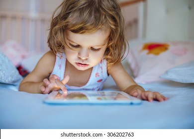 little girl playing tablet.
