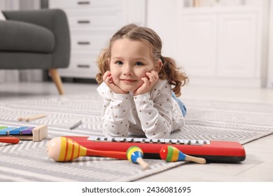 Little girl playing with toy musical instruments at home - Powered by Shutterstock