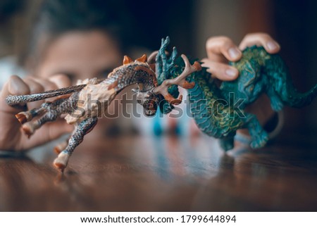 Little girl  playing with toys.Fantastic character children toys characters, dragons.Closeup.