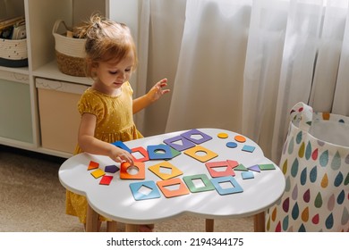 A Little Girl Playing With Wooden Shape Sorter Toy On The Table In Playroom. Educational Boards For Color And Shapes Sorting For Toddler. Learning Through Play. Developing Montessori Activities.