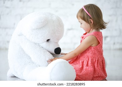 A Little Girl Plays With Big Soft Bear Toy  In The Room