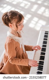Little Girl Plays A Big White Piano In A Bright Sunny Room
