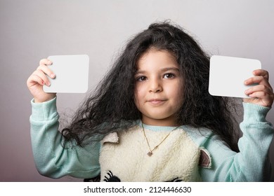 Little girl portrait holding two flash card in hands, preschooler educational material learning objects . flash cards slection path included. 
