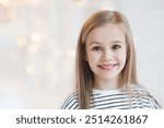 Little girl portrait at home. Funny child smiling and looking at camera