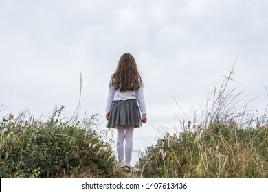 Little girl posing back to back among the flowers